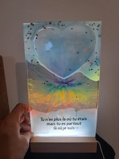 Lampe en résine avec un cœur lumineux et une inscription inspirante en bas.